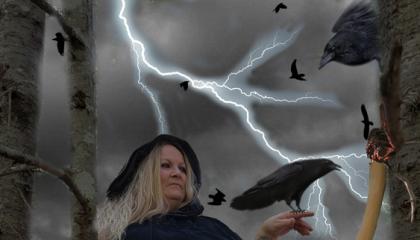 Witch holding a raven in the forest